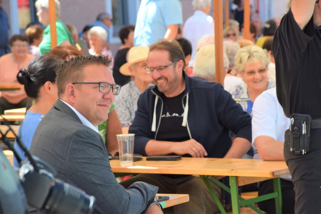 Bürgermeister Christian Haberhauer und Vizebürgermeister Markus Brandstetter sitzen gemeinsam am Biertisch beim Jubiläumsfest in Greinsfurth.