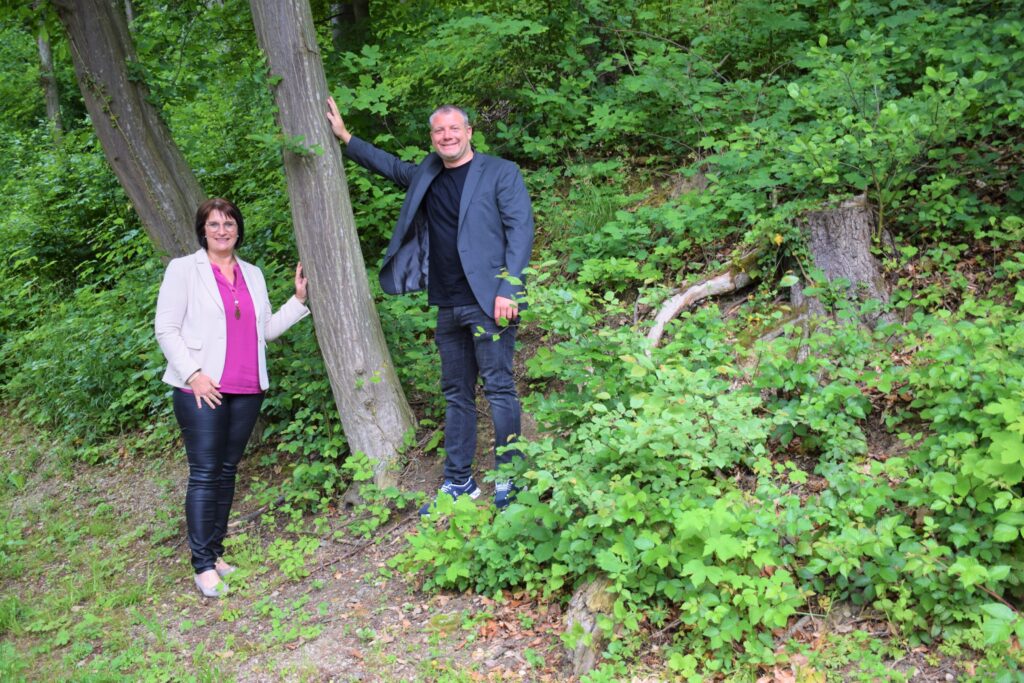 Umweltgemeinderätin Michaela Pfaffeneder und Vizebürgermeister Dominic Hörlezeder symbolisch im Wald zur Bewerbung des neuen Waldmanagementplans.