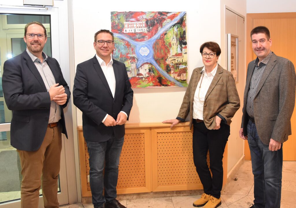 Foto von Vizebürgermeister Markus Brandstetter, Bürgermeister Christian Haberhauer, Roswitha Fröschl und Kulturstadtrat Stefan Jandl. Sie stehen vor einem Gemälde.