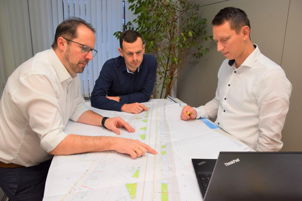 Foto von Vizebürgermeister Markus Brandstetter, Georg Trimmel (Stadtmarketing) und Referatsleiter Mario Holzer. Sie schauen sich einen Bauplan an.