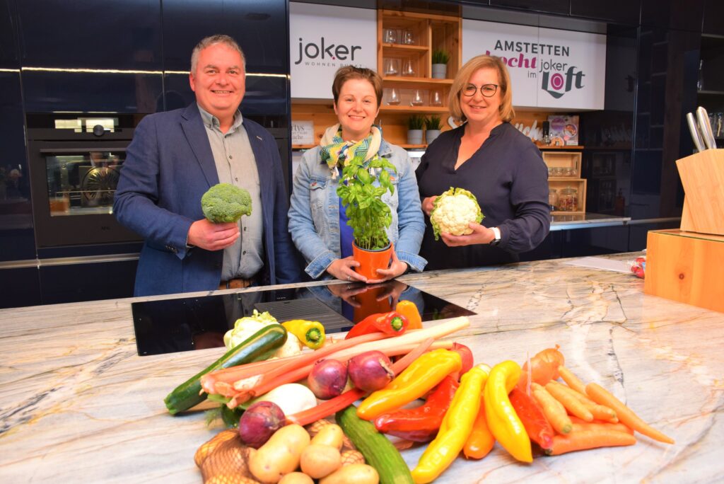 Ortsvorsteher Anton Geister, Diätologin Sabine Zeller, Gesundheitsgemeinderätin Claudia Weinbrenner stehen in der Küche vor einem bunten Gemüsekorb