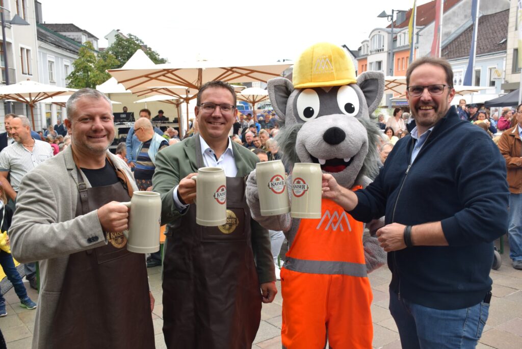 Bürgermeister Christian Haberhauer, die Vizebürgermeister Markus Brandstetter und Dominic Hörlezeder und Wolfi prosten sich mit Bierkrügen zu