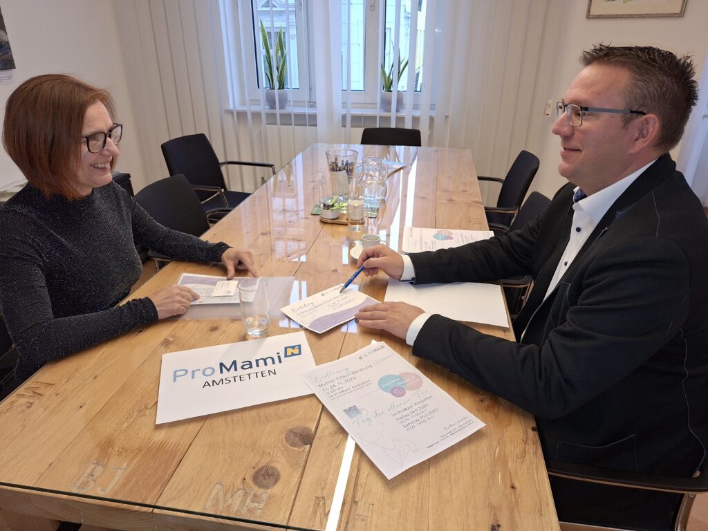 Beatrix Cmolik (ProMami Amstetten), Bürgermeister Christian Haberhauer sitzen mit Unterlagen an einem Tisch und besprechen sich